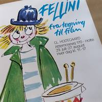 udstillings plakat Fellini, Mand med sort hat og grøn jakke på hvid baggrund med teksten Fillini fra tegning til film.